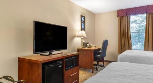 a hotel room with a television and a desk with a bed at Comfort Inn Foxboro - Mansfield in Foxborough