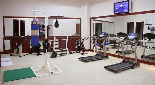 a gym with several tread machines in a room at Dunhuang Grand Soluxe Hotel in Dunhuang