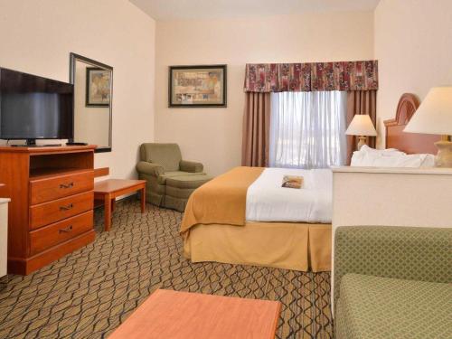 a hotel room with a bed and a television at Quality Inn & Suites Jefferson City in Jefferson City