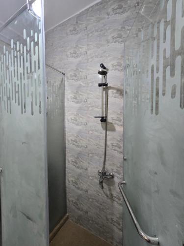 a shower stall in a bathroom with a stone wall at Alex Gate apartment - families only in Alexandria