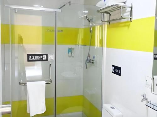 a bathroom with a shower with yellow and white stripes at 7 Days Inn Hohhot University East Street in Hohhot