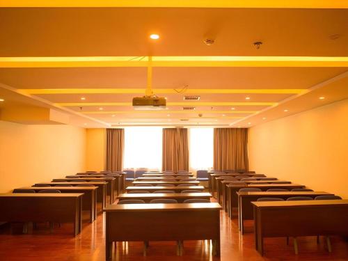 a room with rows of tables and chairs at GreenTree Inn Fuyang Yijing International North Business in Fuyang