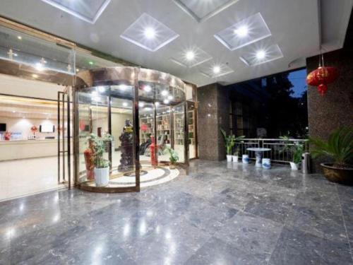 a large lobby with a store with potted plants at GreenTree Inn Fuyang Yijing International North Business in Fuyang