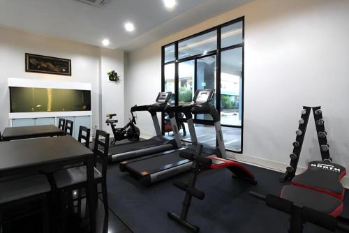 a gym with several treadmills and machines in a room at Thanburi Hotel in Udon Thani