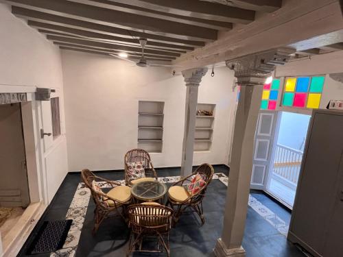 ein Zimmer mit Tisch und Stühlen und einem Balkon in der Unterkunft Savita Ba Ni Haveli A Heritage House in Ahmedabad