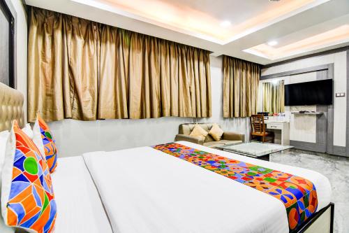 a hotel room with two beds and a couch at FabHotel Aafreen International in Kolkata