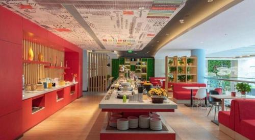 a restaurant with red and green cabinets and a counter at ibis xian North Second Ring Weiyang Rd Hotel in Xi'an