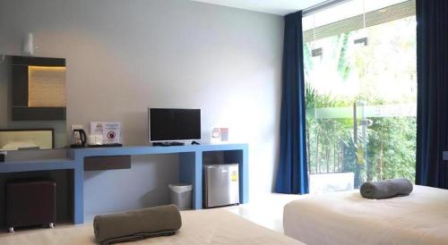 a bedroom with a bed and a desk with a television at Sea Suite Villa in Chaweng
