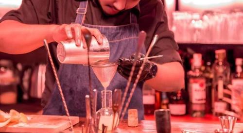 a man is making a drink in a glass at Sea Suite Villa in Chaweng