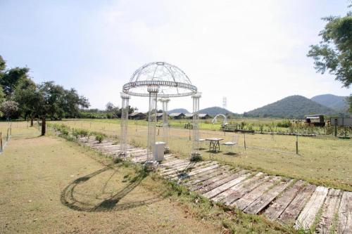 a garden with a gazebo in a field at OYO 75374 Baan Rak Mai in Kanchanaburi