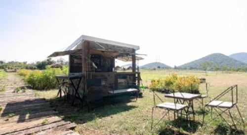 a small shack with two chairs and a table at OYO 75374 Baan Rak Mai in Kanchanaburi