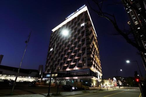 a tall building with a light on top at night at Kintex by K-tree in Goyang