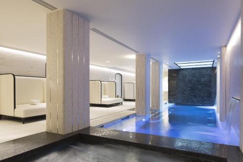 a room with a pool of water and columns at Le Narcisse Blanc in Paris