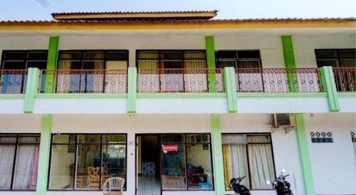 a building with a balcony with a motorcycle parked in front at Hotel O P3 Guest House in Bandung