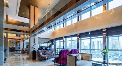 a living room with a lot of windows at Chengdu Rising Butterfly Hotel in Chengdu