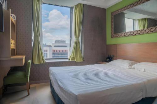a bedroom with a large bed and a large window at Largos Hotel in Hong Kong