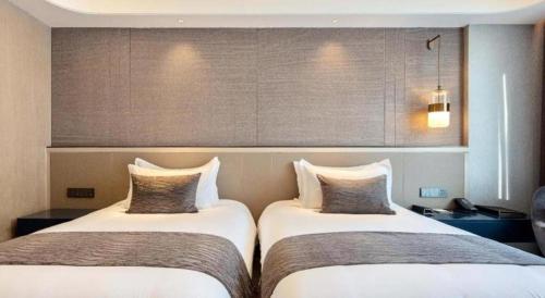 two beds in a hotel room withermottermottermott at Taiyi International Hotel in Wenzhou