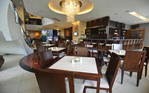 a dining room with tables and chairs in a restaurant at Lancaster Hotel Manila in Manila