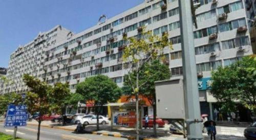 a large apartment building on a city street with trees at Xian Union Alliance Atravis Executive Hotel in Xi'an