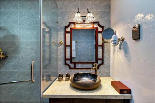 a bathroom with a sink with a mirror and a shower at Zen B Hoian Villa in Cam Thanh