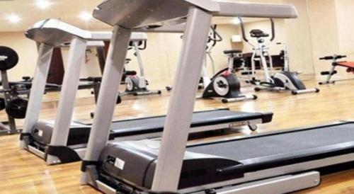 a gym with several treadmills and exercise bikes at Ramada Plaza Shenyang Citycenter in Shenyang