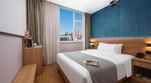 a bedroom with a large bed and a large window at New Beacon Sunyee SPA Hotel in Wuhan