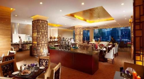 a restaurant with a bar and a dining room at Gaosu New Century Hotel International Anhui in Hefei