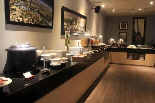 a kitchen with a counter with alot of dishes at Pomelotel Patra Kuningan Jakarta in Jakarta