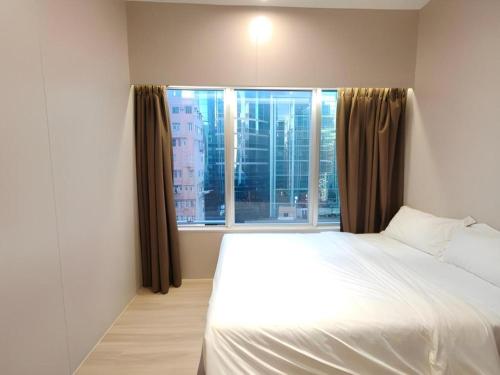 a bedroom with a bed and a large window at H1 Hotel in Hong Kong
