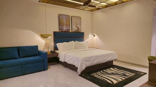 a bedroom with a bed and a blue couch at Blue horiizon valley retreat in Khed