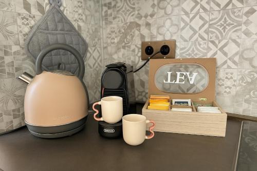 a tea kettle and two cups on a counter at Courts & Coasts few steps from Tennis courts, Country Club and Montecarlo Beach in Roquebrune-Cap-Martin