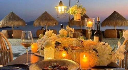 a dining table with candles and wine glasses on a beach at The Century Seaview Hotel in Shenzhen