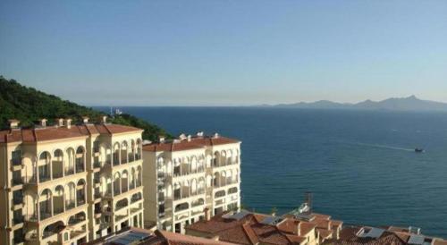 a view of two buildings and the ocean at The Century Seaview Hotel in Shenzhen