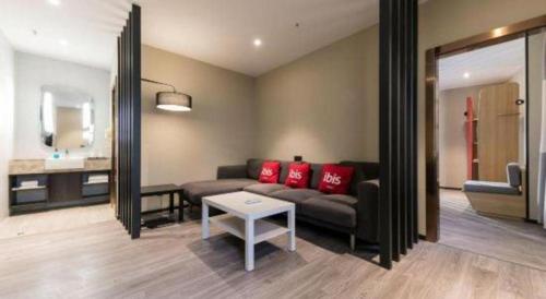 a living room with a couch and a table at Ibis Nantong Qingnian in Nantong