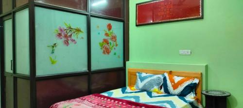 a bedroom with a bed and some paintings on the wall at MangalMurti Himalyan Hotel in Almora