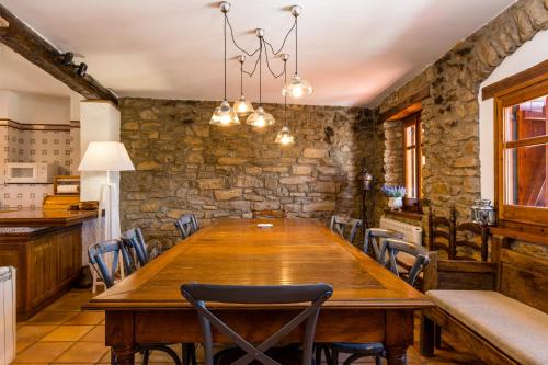 une salle à manger avec une grande table et des chaises en bois dans l'établissement Casa Joan de Fontsagrada, à Fontsagrada