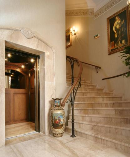 a vase sitting on the floor next to a staircase at Grand Hotel London in Varna City