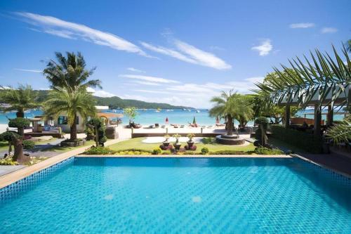 a large swimming pool with a view of the ocean at Phi Phi Nice Beach Hotel Hip in Phi Phi Don