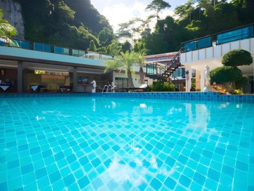 a large blue swimming pool in front of a building at Phi Phi Nice Beach Hotel Hip in Phi Phi Don