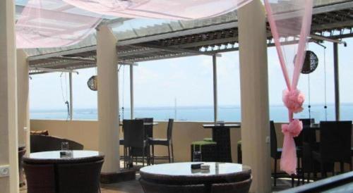 a room with tables and chairs with a view of the ocean at The Belagri Hotel and Convention in Sorong