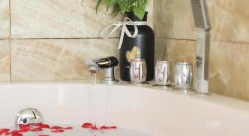 a bathroom sink with a faucet and a vase at Viet Village Hotel in Hanoi