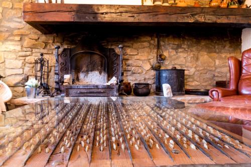 a living room with a stone fireplace and a couch at Casa Joan de Fontsagrada in Fontsagrada