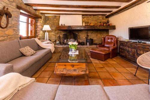 sala de estar con sofá y chimenea en Casa Joan de Fontsagrada, en Fontsagrada