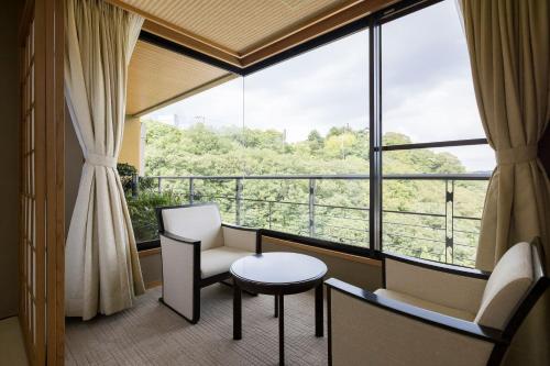 a room with a table and chairs and a large window at Kinzan in Kobe