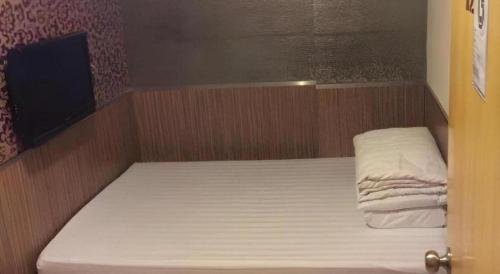 a small bed in a small room with at New Mong Kok Guest House in Hong Kong