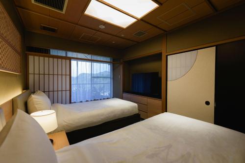 a hotel room with two beds and a window at Kinzan in Kobe