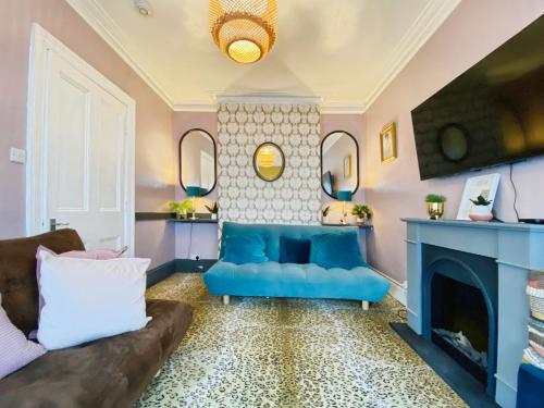 a living room with a blue couch and a fireplace at Bournemouth Beach Boutique with Hot Tub in Bournemouth