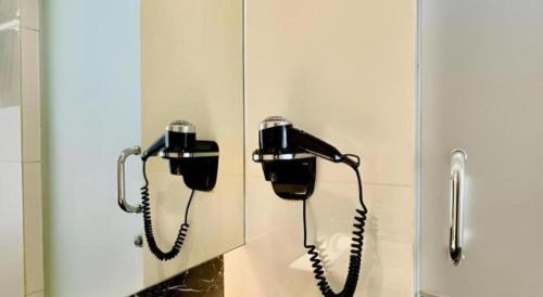 two phones hanging on a wall in a cubicle at Brits Hotel Karawang in Karawang