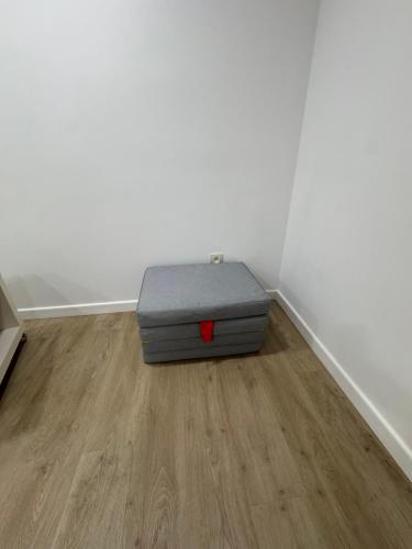 a gray ottoman sitting in the corner of a room at Studio Confort by Titou - Jumet in Charleroi