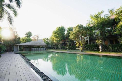 a swimming pool with a gazebo next to a resort at The Buffalo Amphawa in Samut Songkhram